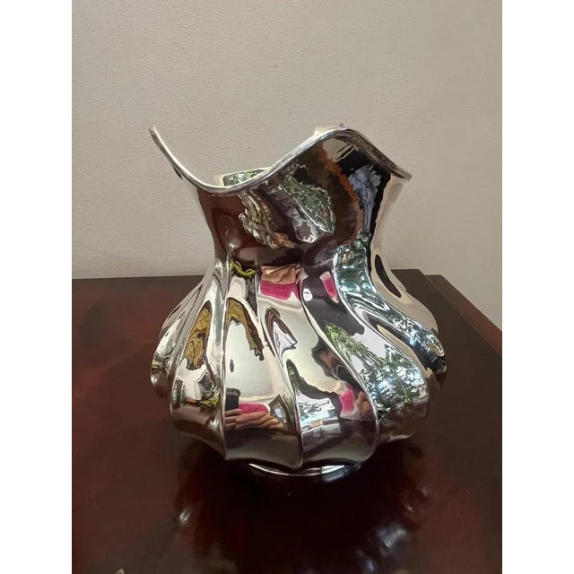 Very elegant and sinuous jug in hand -worked 800 silver, "Torchon" processing. Italian production of the 80s. It is...