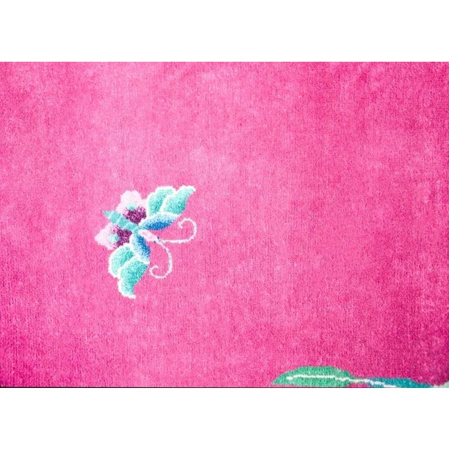 A beautiful early 20th century Chinese Art Deco rug with a brilliant fuchsia field surrounded by a border with large-scale...