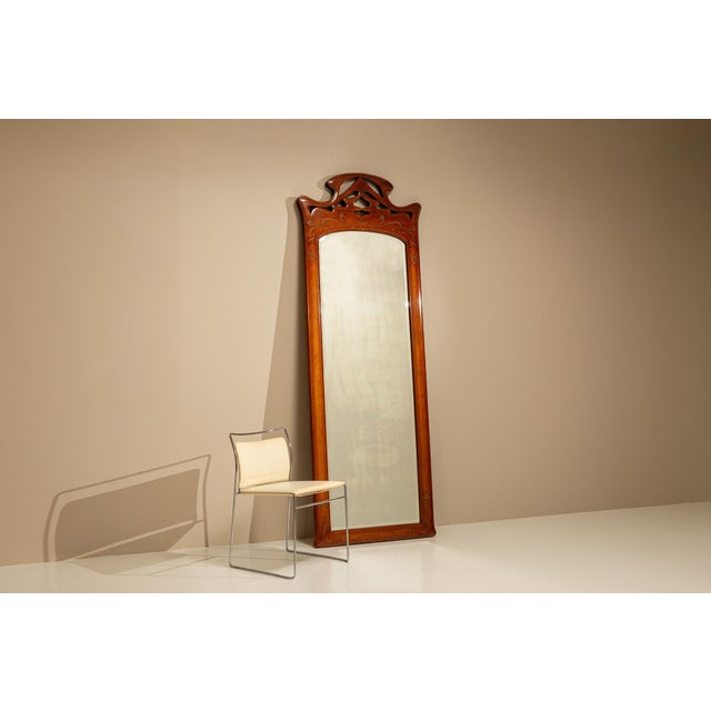 The warmth of solid walnut and the grace of fluid lines come together in this elegant full-length mirror from the Art...