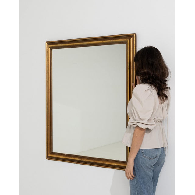 A mirror whose gold gilt frame with dark wood outer edge gives it real character at first glance. It was made in France...