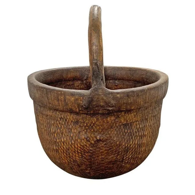 A mid-20th century Chinese woven reed gathering basket with a thick bentwood handle attached with simple iron straps, and...