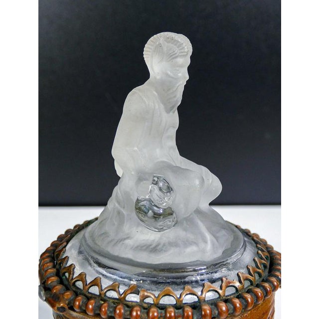 Scatolina in bronzo sormontata da scultura di satiro in vetro, in parte satinato e in parte lucido origine prob....