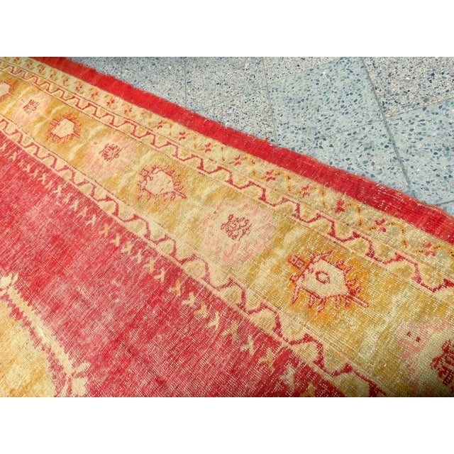 Antique oversize Turkish Oushak rug in distressed "country house" condition, beautiful coral background colour.