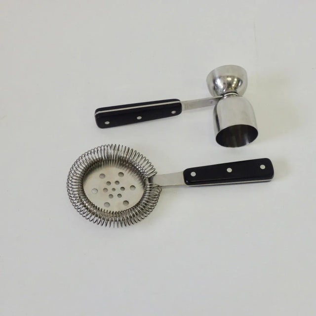 Stainless steel with ebony black synthetic handles. Cohr of Denmark drinks strainer and shot measure. Very well made....