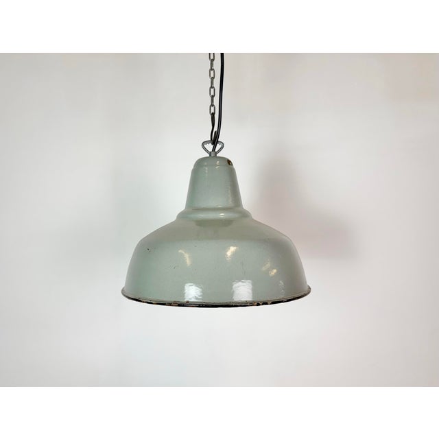 Industrial grey enamel factory pendant light made in former Czechoslovakis during the 1960s. White enamel inside the...