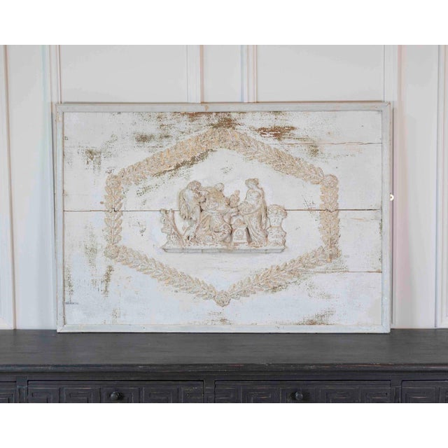 An elegant antique French wooden panel featuring a finely carved neoclassical figural relief framed by a delicate laurel...