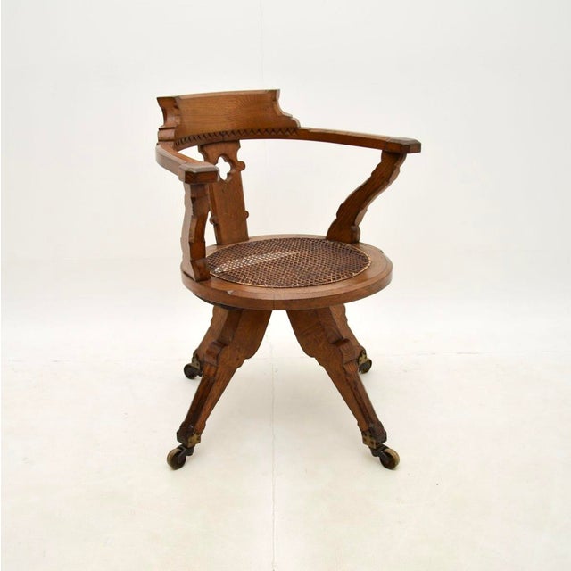 A superb antique Victorian Gothic revival solid oak swivel desk chair, made in England and dating from around the...