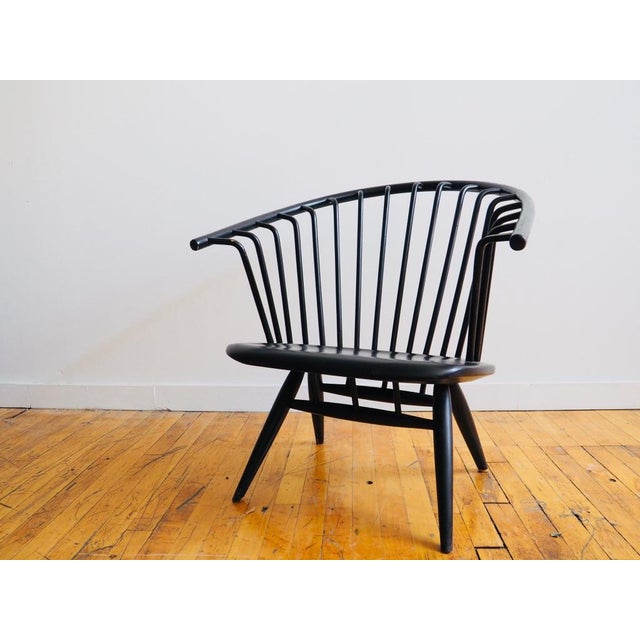 A low‑profile lounge chair with a sleek, sculptural, spindle back wood frame and timeless Scandinavian design. Crafted by...