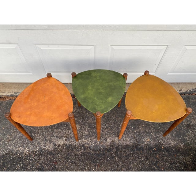A fab set of three Mid Century Modern stacking or nesting side tables. Each rounded triangular 3 legged table has a...