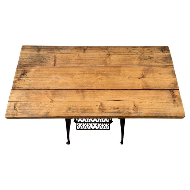 A distinctive vintage 20th-century table, combining an original Singer cast iron sewing machine base with a substantial...