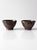 A pair of vintage handmade studio pottery bowls with hand-painted floral decoration in olive and cream over a rich iron-...