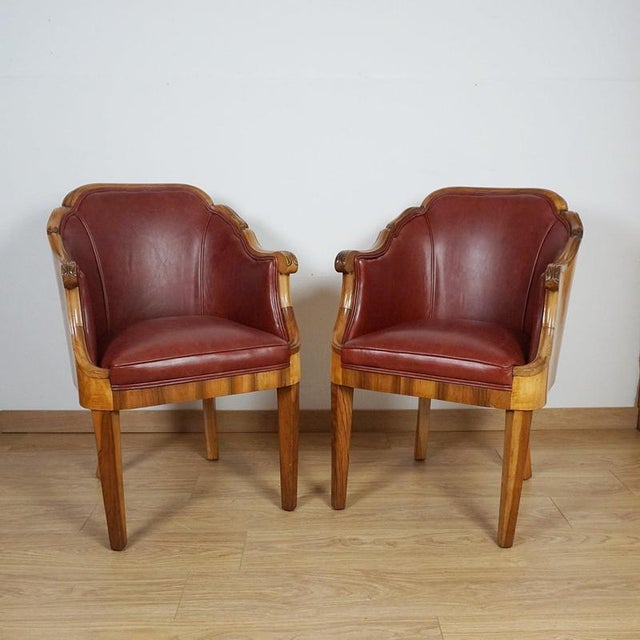 A pair of art deco armchairs designed by maurice adams. Burr and solid walnut with satin birch wraparound veneer and...