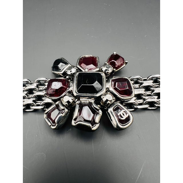Chanel bracelet with Gripoix dark red and black melted glass ornement in the middle. Chanel steel Chain . Chanel logo on...