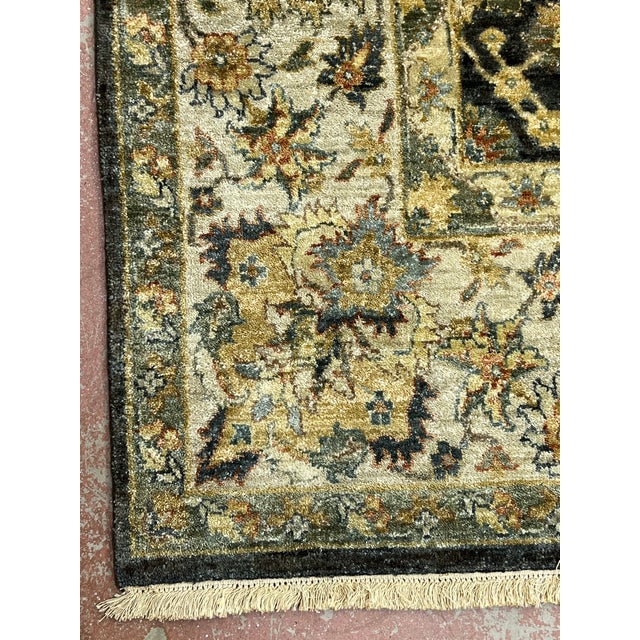 Indo Agrah rug, hand knotted in India from 100% wool. Measuring 7’9” x 10’1”, the rug features a rich dark navy field...