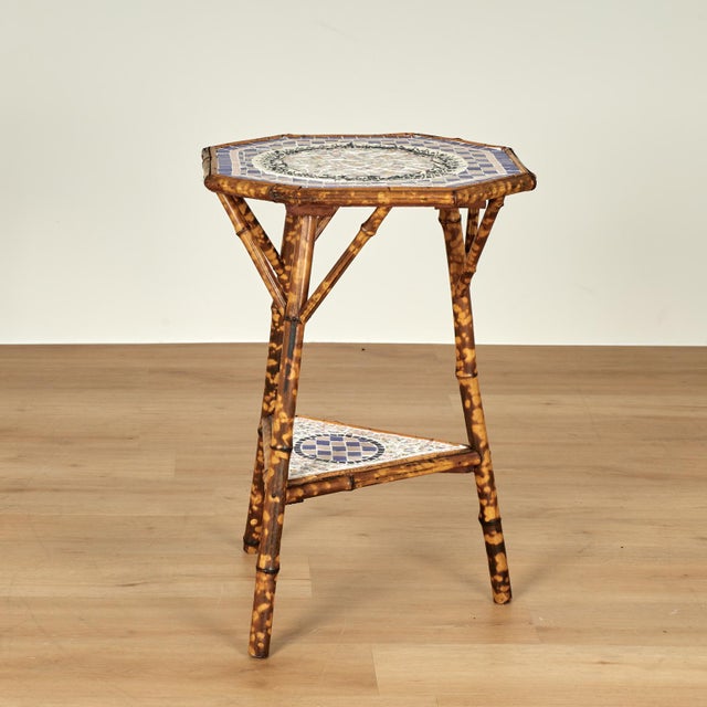 Standout 19th century English stand crafted in burnt bamboo with an octagon top and triangular base, having later tile...
