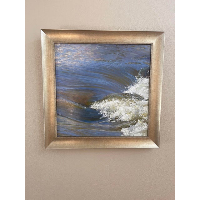 This oil painting captures the fluid movement of water, with gentle waves rolling and crashing in a dance of blues and...