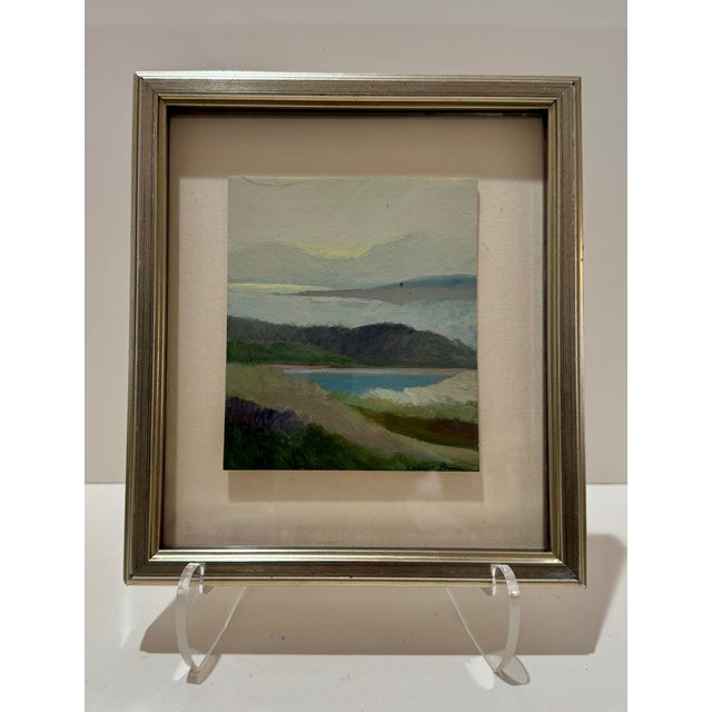 A refined vintage landscape oil painting featuring softly layered hills, water, and sky rendered in muted, atmospheric...