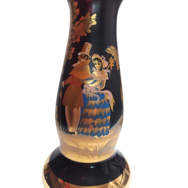 Stunning purple glass vase with a hand-painted scene all around the piece. On the front of the vase is a charming Regency-...