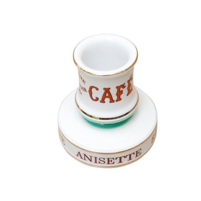 A traditional French, Parisian cafe ceramic match striker. Writing around bottom edge reads 'Vin, Biere, Anisette, Rhum,...