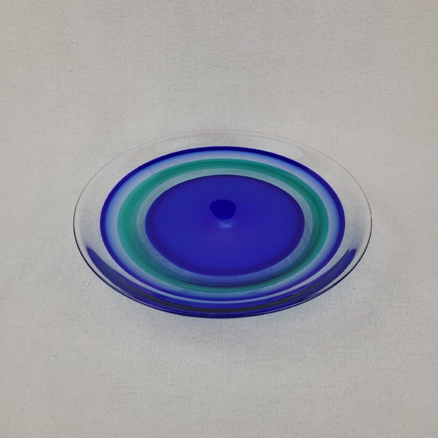 Orrefors art glass bowl designed by Olle Alberius, featuring a vibrant concentric ring pattern in shades of cobalt blue,...