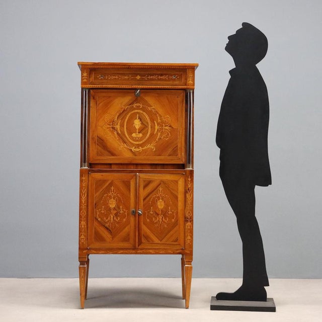 Empire-style walnut secretaire with filleting, floral inlays, and maple vases. Slightly projecting drawer under the top...