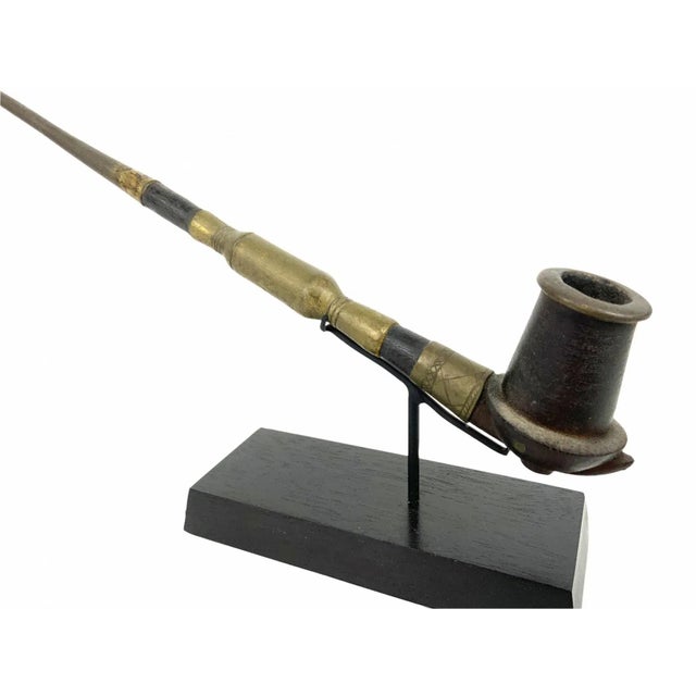 An early 20th century gracefully crafted African pipe from the Dinka tribe on a custom iron and wood stand. The Dinka are...