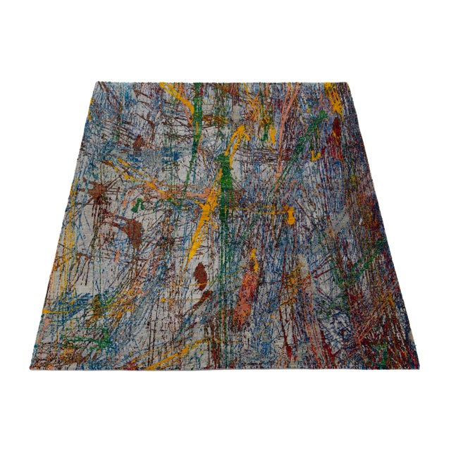 This contemporary hand-knotted rug boasts a breathtaking abstract design in vibrant hues that effortlessly draws the eye....