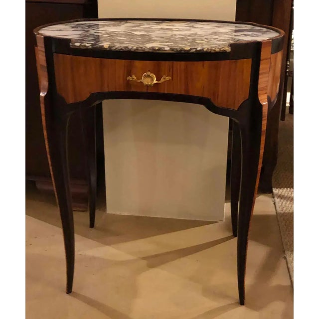 An oval shape 18th century Louis XV table with marble top. Features green striped interior of drawer. French, circa...