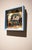 Something in the Way by Nadezda | Oil on panel of a man slumped in a chair with a gramophone nearby For Sale - Image 4 of 5
