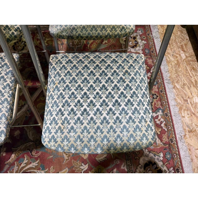 Set of 12 folding reception chairs, circa 1960, made of chromed tubular metal with a period-specific X-folding mechanism....