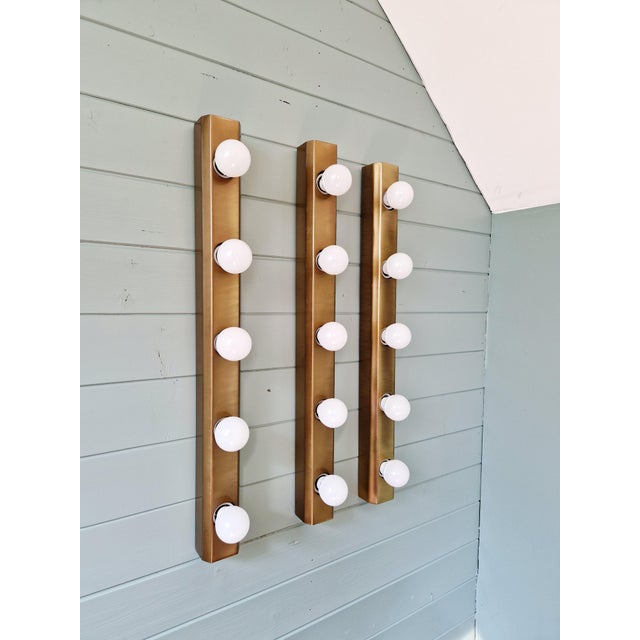Trio of large wall sconces in solid brushed brass (bronze finish), 1970s-80s. each sconce has five light points. The...