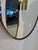Elegant vintage wall mirror featuring a distinctive shield-inspired silhouette with a sculptural brass frame and...