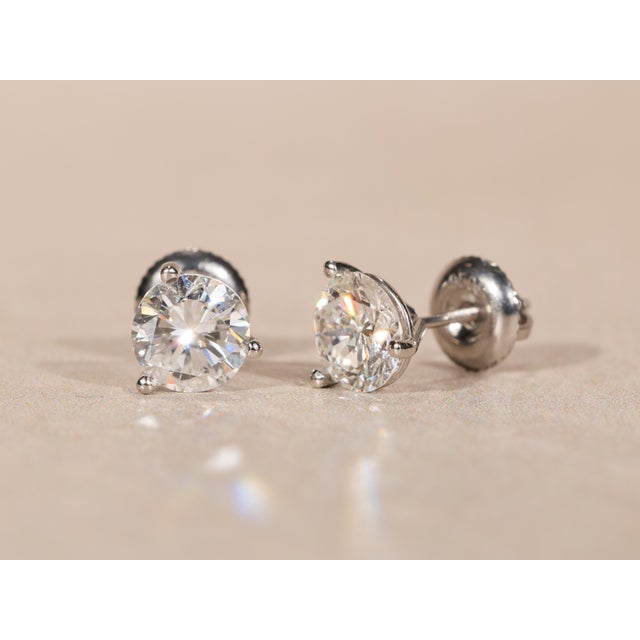 The Virgil Village 1.96 Carat Total Weight Diamond Stud Earrings in Platinum Martini Settings. The earrings are set with a...