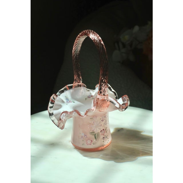 Beautiful collector Fenton glass basket in the shade dusty rose. Hand painted with floral motifs on the outside and inner...