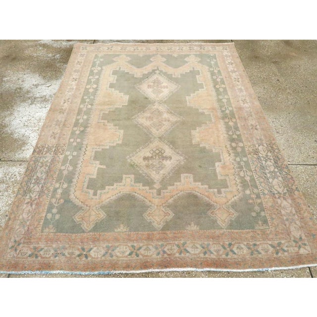 This mid-20th-century Persian Afshar rug presents a softly geometric composition in muted blue-green, pale peach, ivory,...
