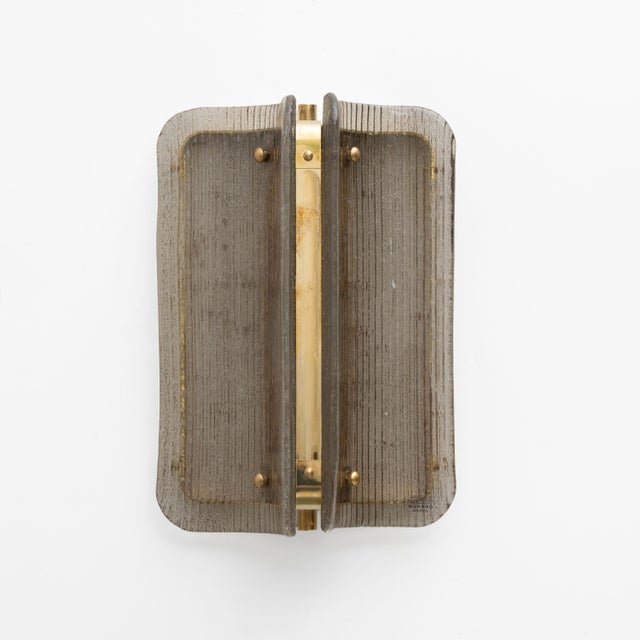 An elegant pair of italian wall sconces made of curved and fluted murano glass panels in a refined shade of grey. The...