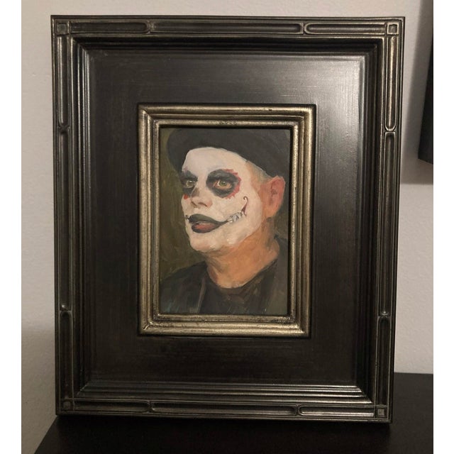 This oil painting presents a striking portrait of a figure adorned with traditional Day of the Dead face paint, capturing...