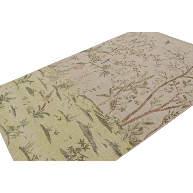 Hand-knotted in wool, this 6x9 modern pictorial rug, originating from India, has been inspired by botanical designs, with...