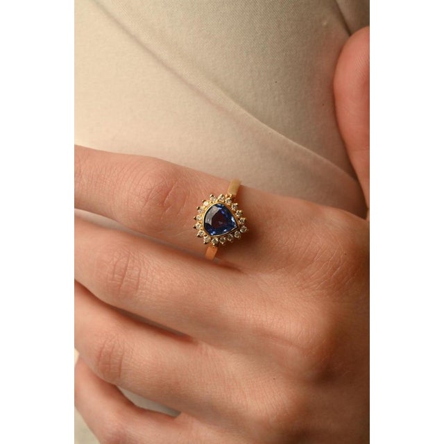 Blue Sapphire Diamond Halo Ring in 18K Gold featuring natural sapphire of 1.4 carats and diamonds of 0.25 carats. The...