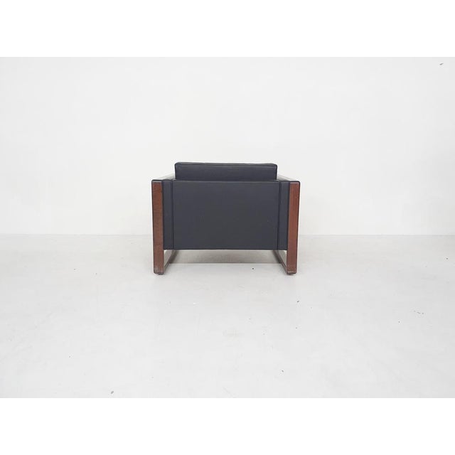 Black leather lounge chairs with wooden arm rests / feet. Wood is in used condition. One chair has a scratch on the...