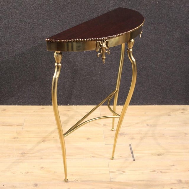 Mid-20th-century Italian console table. Chiseled and gilded brass furniture with a mahogany top. This compact console...