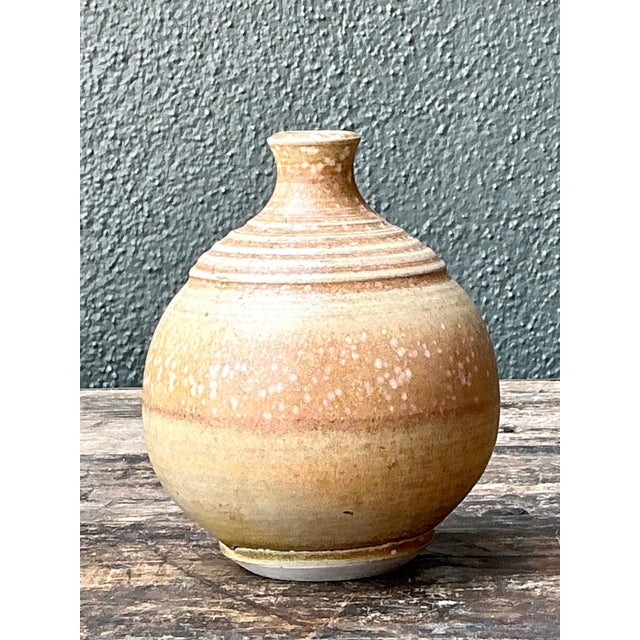 This vintage studio pottery vase is a refined example of mid-20th-century artisanal craftsmanship, celebrating the beauty...