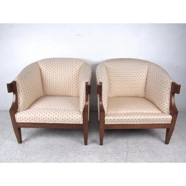 This unique and comfortable pair of matching arm chairs features unique upholstery, tapered legs, and unique stubbed...