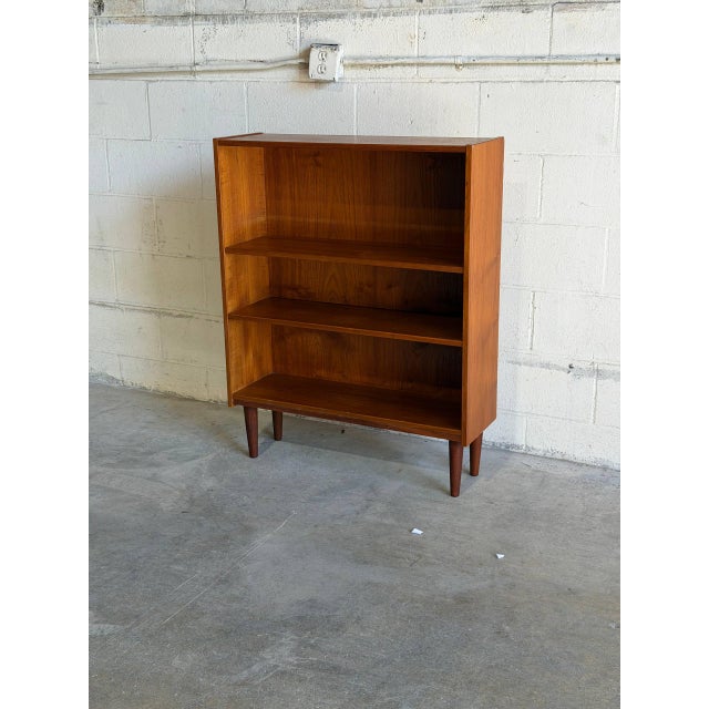 Beautiful vintage Danish bookcase crafted in warm teak with elegant Scandinavian Modern proportions and clean minimalist...