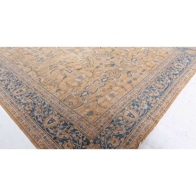 A late 19th century Indian carpet, the golden yellow field with an overall blue and beige trellis of palmettes and...