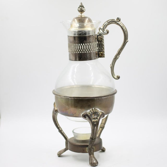 This exquisite antique carafe/jug with warmer comes from Art Nouveau and impresses with its elegant, silver-plated design....