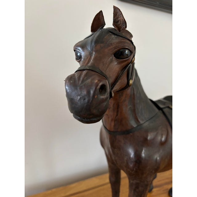 One of the larger of this type we have seen, this vintage rustic pieced leather horse sculpture features inset glass eyes....