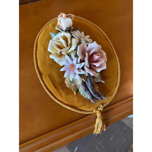 Capodimonte Flowers on a Wall Plaque with Gold Velvet Material and a Tassel. Pinkish , Yellow and Purple Color Flowers .