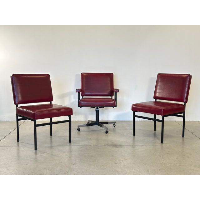 1960s office set consisting of two chairs and a swivel armchair, black lacquered iron structure, steel and red/burgundy...