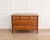 A refined Louis XVI walnut chest of drawers opening on the front with five drawers arranged in three rows, exemplifying...